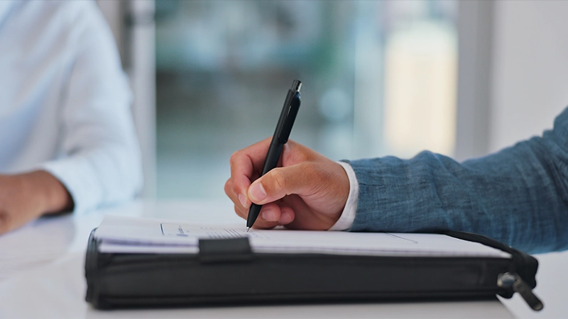 Closeup Of Lawyers Hands Writing On Legal Document In Office