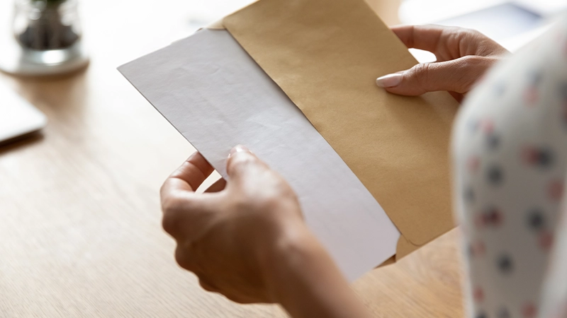 Hands Of Woman Receiving Legal Notice Letter At Workdesk